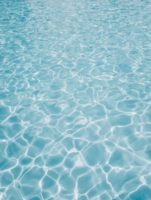 Clear blue pool water with light reflections
